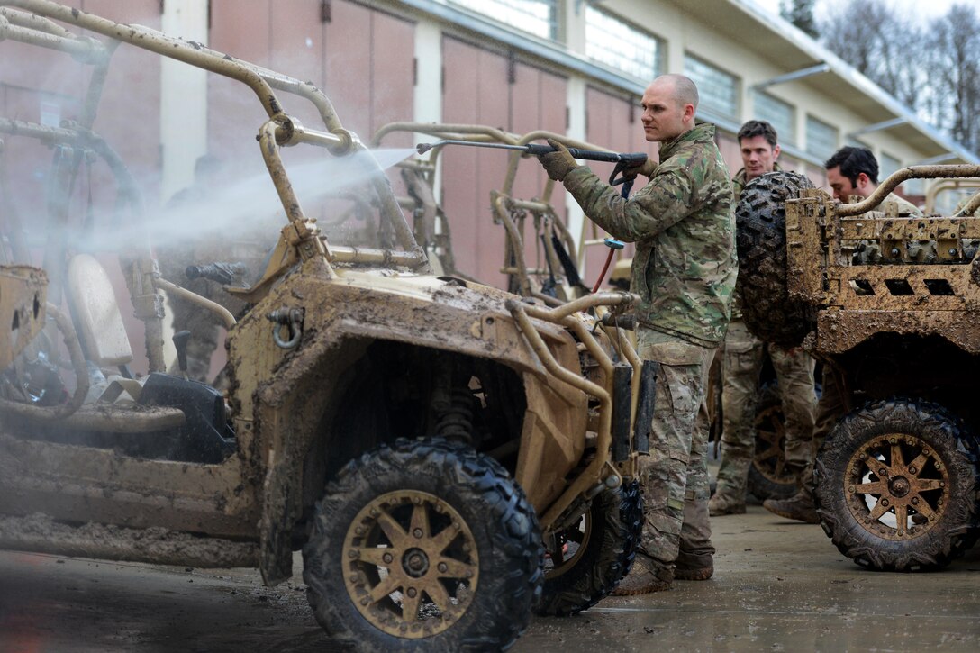 A U.S. soldier uses a high powered hose to spray down and clean up a MRZR4 LT-All Terrain Vehicles after testing their capabilities in the Boeblingen Local Training Area, Germany, Jan. 5, 2016. U.S. Army photo by Jason Johnston