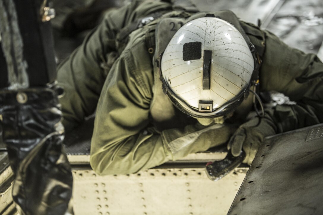 Lance Cpl. Jacob Burnette, a crew chief with Marine Heavy Helicopter Squadron 302, prepares to conduct external lifts in conjunction with Combat Logistics Battalion 2 at Camp Lejeune, N.C., Jan. 6, 2016. The crew chief’s responsibilities when conducting external lifts are to direct the pilot and co-pilot as they attach the load to the CH-53E Super Stallion allowing the pilot to solely focus on maneuvering the aircraft. (U.S. Marine Corps photo by Lance Cpl. Erick Galera/Released)