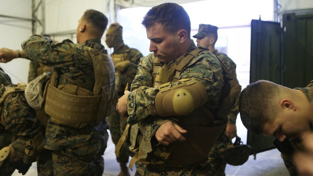 Marines with 2nd Supply Battalion, Combat Logistics Regiment 25, put on their personal protective equipment in preparation for a Humvee Egress Assistance Trainer at Marine Corps Base Camp Lejeune, N.C., Jan. 7, 2015. The purpose of the training was to teach the Marines about the dangers during Humvee rollovers and how to properly react if ever faced it. 