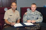 Navy Rear Adm. Vincent Griffith, director of DLA Logistics Operations, and Army Maj. Gen. Allen W. Batschelet, U.S. Strategic Command chief of staff, sign a memorandum of agreement Jan. 7 at USSTRATCOM Headquarters, Offutt Air Force Base, Nebraska.