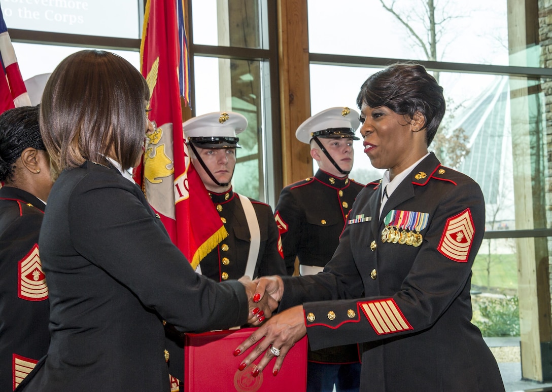 U.S. Marine Corps MGySgt Shalanda Raynor (right), Combat Camera chief, Marine Corps Base Quantico, Va., is retired by (ret.) Capt. Nicole Hooks at the Semper Fidelis Chapel, National Museum of the Marine Corps, Triangle, Va., Dec. 30, 2015. Raynor enlisted in the Marine Corps in 1993 and was trained as a still combat photographer. She is the first female in Marine Corps history, in her MOS, to achieve the rank of Master Gunnery Sergeant, and has served faithfully for 23 years.  (Official United States Marine Corps photo by Kathy Reesey/Not released)