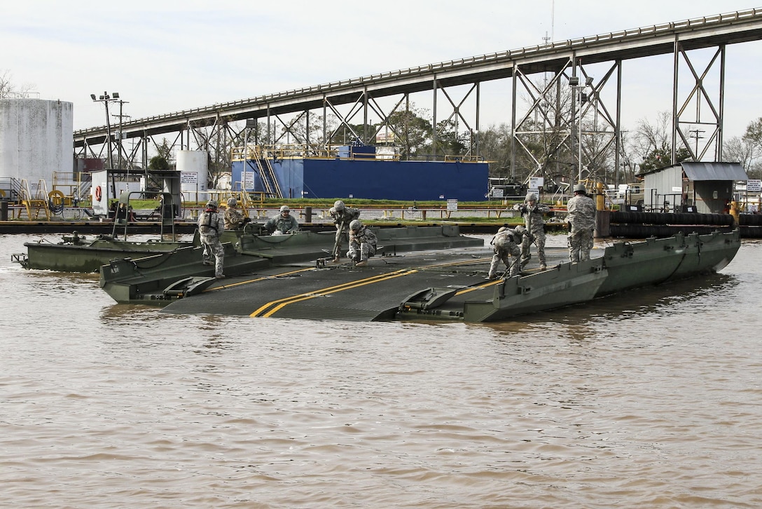 Soldiers assemble a ribbon bridge in Amelia, La., Jan. 8, 2016, to transport crew, equipment and supplies to build a 12,550-foot levee on Avoca Island before expected river flooding in Morgan City, La. Louisiana Army National Guard photo by Spc. Garrett Dipuma 