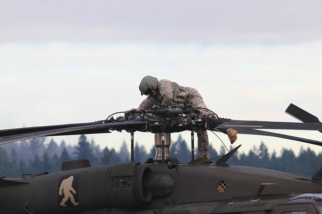 A soldier prepares a UH-60 Black Hawk to depart from Joint Base Lewis-McChord, Wash., and head to the National Training Center on Fort Irwin, Calif., for training, Jan. 9, 2016. The soldier is assigned to 2nd Battalion, 158th Aviation Regiment, 16th Combat Aviation Brigade, 7th Infantry Division. U.S. Army photo by Capt. Brian Harris