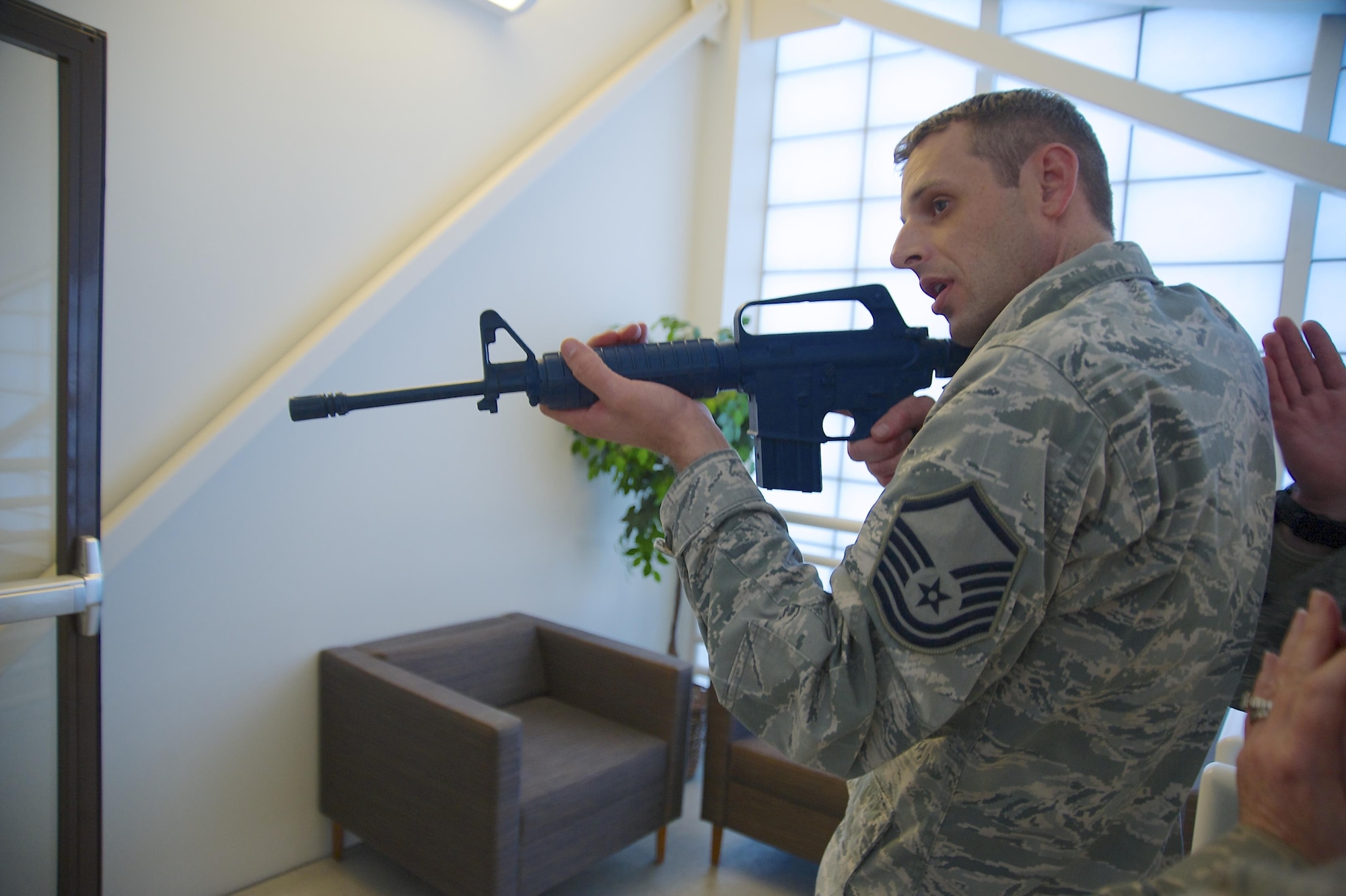 Master Sgt. Cam Vaillant, 446th Aeromedical Evacuation Squadron, practices tactical formation as he enters a room carrying a mock rifle Jan. 10, 2016, at Hangar 12. This training is part of the hands-on portion of an expeditionary active shooter response course. (U.S. Air Force Reserve photo by Staff Sgt. Madelyn McCullough)