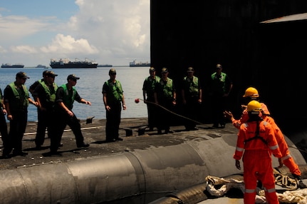 160107-N-PN275-032 DIEGO GARCIA, British Indian Ocean Territory (Jan. 7, 2016) Sailors from guided-missile submarine USS Florida (SSGN 728) receive a mooring line from a tug boat to be brought alongside submarine tender USS Emory S. Land (AS 39) in Diego Garcia. Emory S. Land is a forward deployed expeditionary submarine tender on an extended deployment conducting coordinated tended moorings and afloat maintenance in the U.S. 5th and 7th Fleet areas of operations. (U.S. Navy photo by Mass Communication Specialist 3rd Class Zachary A. Kreitzer/Released)
