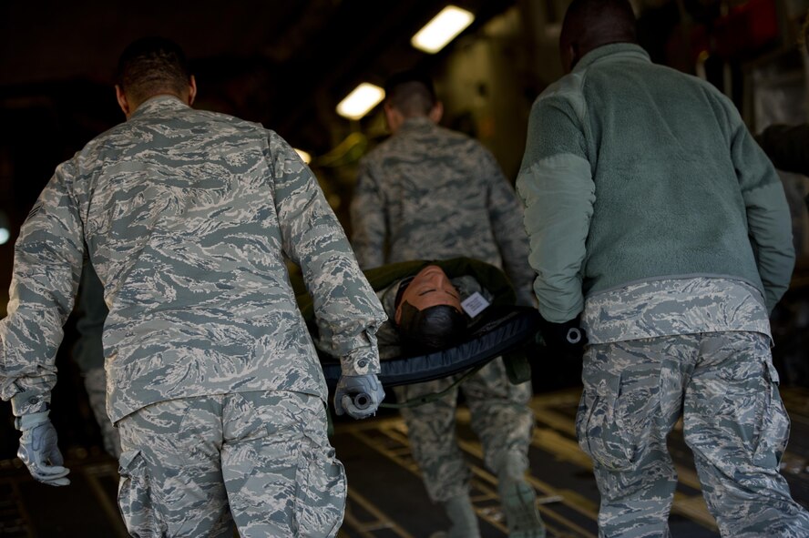 Members of the 446th Aeromedical Staging Squadron work to load patients onto a C-17 Globemaster during a monthly patient load exercise at Joint Base Lewis-McChord, Wash., Jan. 10. The 446th ASTS performed a patient load exercise to practice loading critically wounded members onto the C-17 for evacuation. The ASTS works closely with the 446th Aeromedical Evacuation Squadron to accomplish the mission of loading patients and caring for them in flight. (U.S. Air Force Reserve photo by Staff Sgt. Daniel Liddicoet)