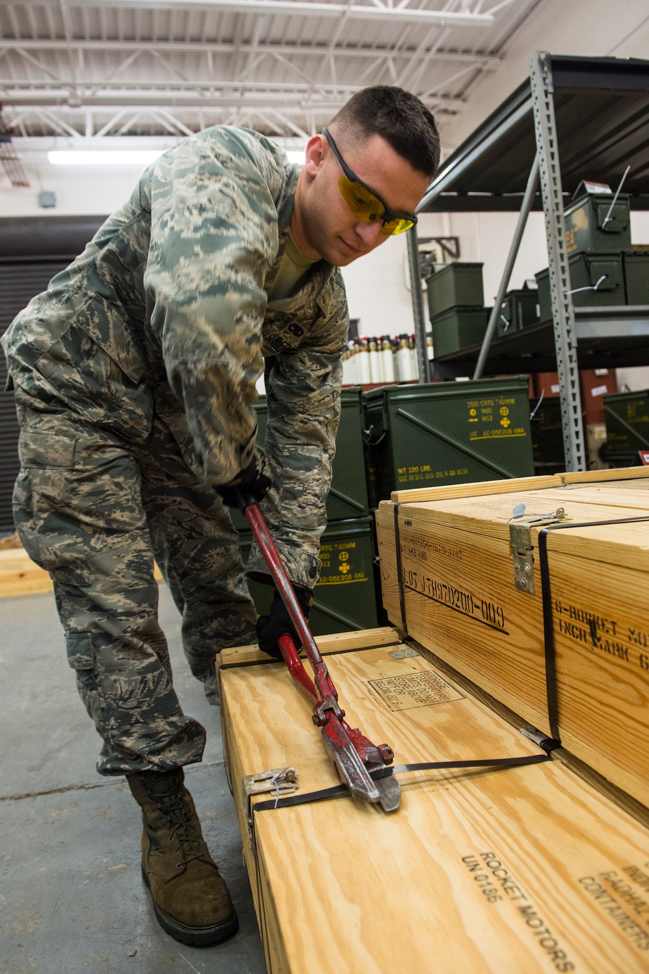 U.S. Air Force Airman Basic Jacob Dechant, 23d Equipment Maintenance Squadron munitions crew member, uses sheers to open a box of rocket motors during a rocket build, Jan. 7, 2016, at Moody Air Force Base, Ga. Members of the munitions flight were tasked to build 600 rockets in a week. (U.S. Air Force photo by Senior Airman Ceaira Tinsley/Released)