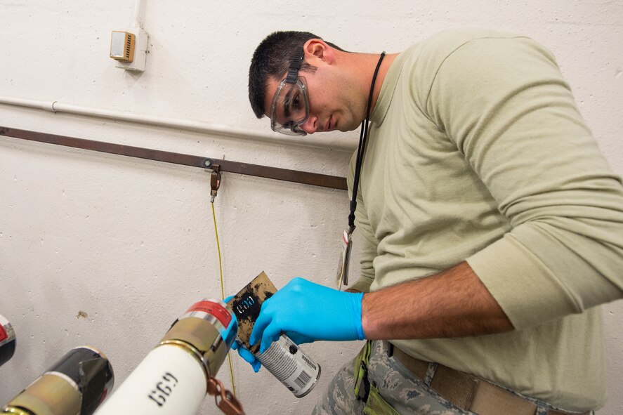 U.S. Air Force Senior Airman Omar Vasquez, 23d Equipment Maintenance Squadron munitions crew chief, spray-paints a 2.75-inch signature practice rocket during a rocket build, Jan. 7, 2016, at Moody Air Force Base, Ga. Vasquez used the paint to attach a weapons stock number to each rocket for identification. (U.S. Air Force photo by Senior Airman Ceaira Tinsley/Released)