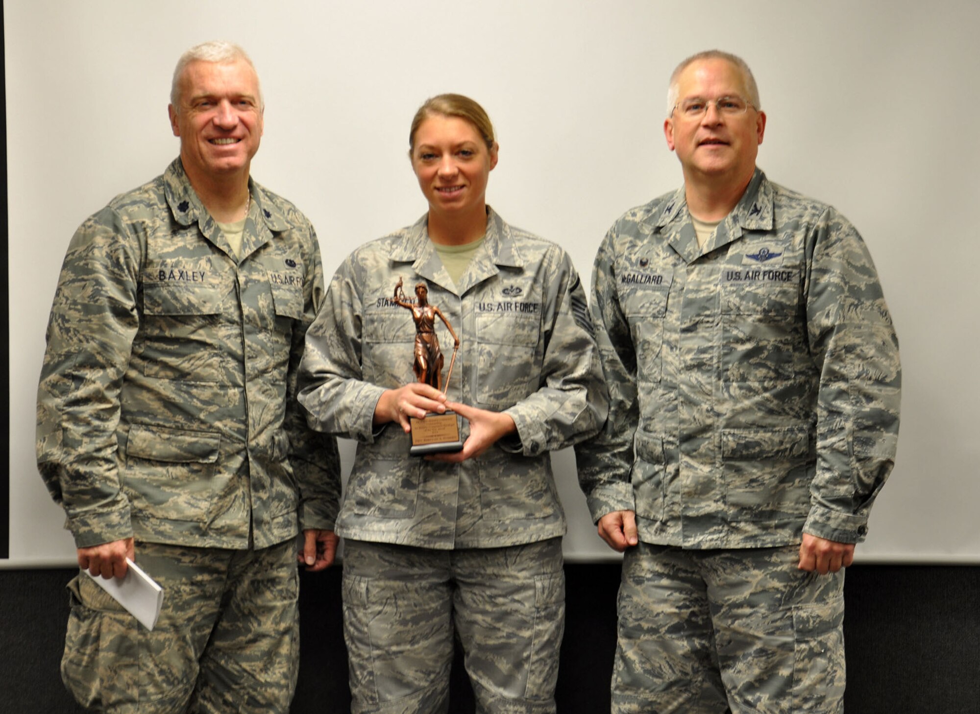 WRIGHT-PATTERSON AIR FORCE BASE, Ohio - Lt. Col. Gregory Baxley, 445th Airlift Wing Staff Judge Advocate (left) and Col. Jeffrey McGalliard, 445 AW Commander, present Master Sgt. Rebeccah Stammen the Justitia statue in recognition of her selection as the Air Reserve Component Paralegal of the Year. (U.S. Air Force photo/Senior Airman Joel McCullough)