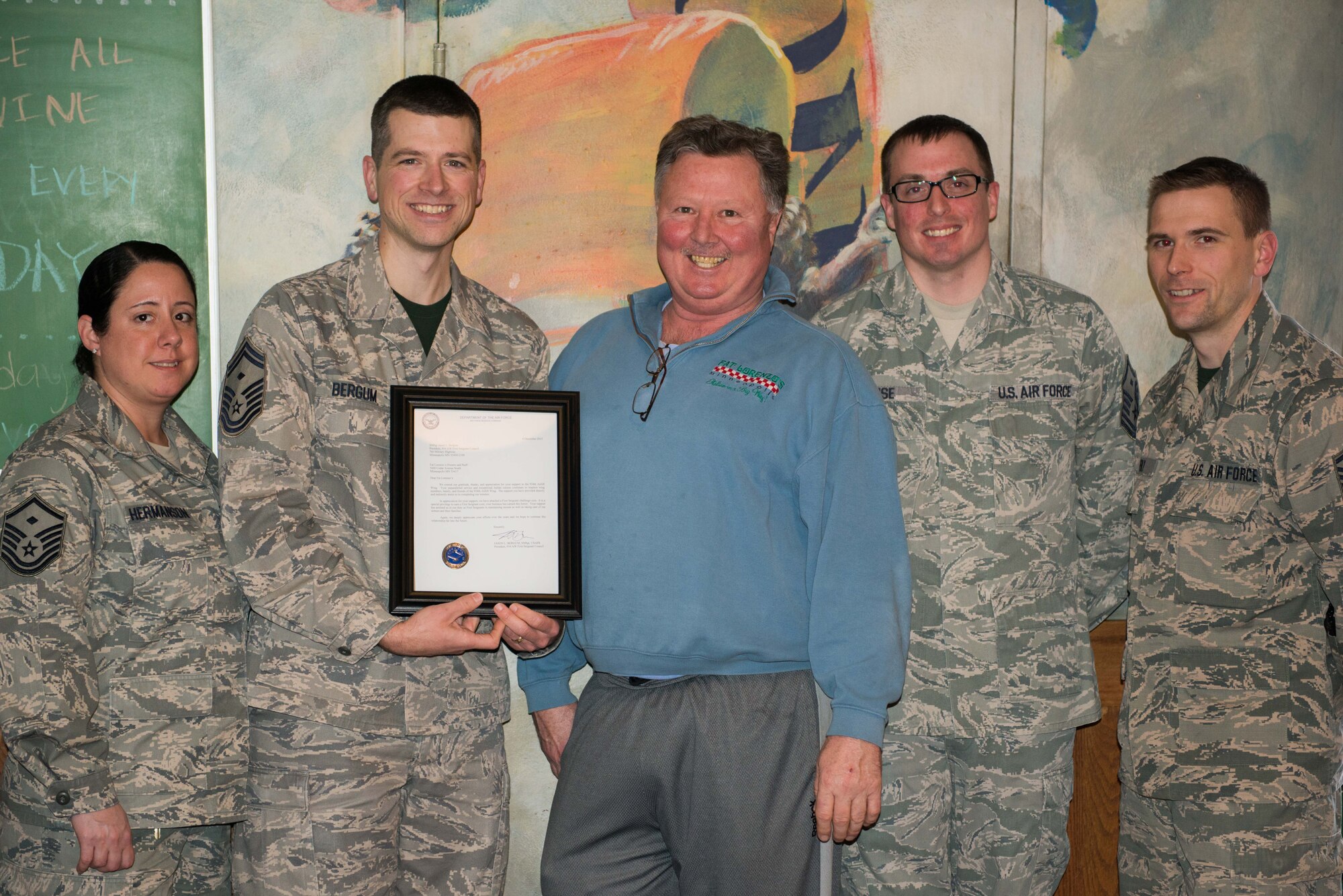 Members of the 934th Airlift Wing First Sergeant Council present a letter of appreciation along with a First Sergeant Challenge coin to Scott Siegel (center) owner of Fat Lorenzo's restaurant in Minneapolis, Minn. Jan. 8.  The First Sergeant's Council wanted to extend their gratitude to the restaurant and staff for the continued support they provide to the Airmen and families of the 934th Airlift Wing. (U.S. Air Force photo by Captain William-Joseph Mojica)