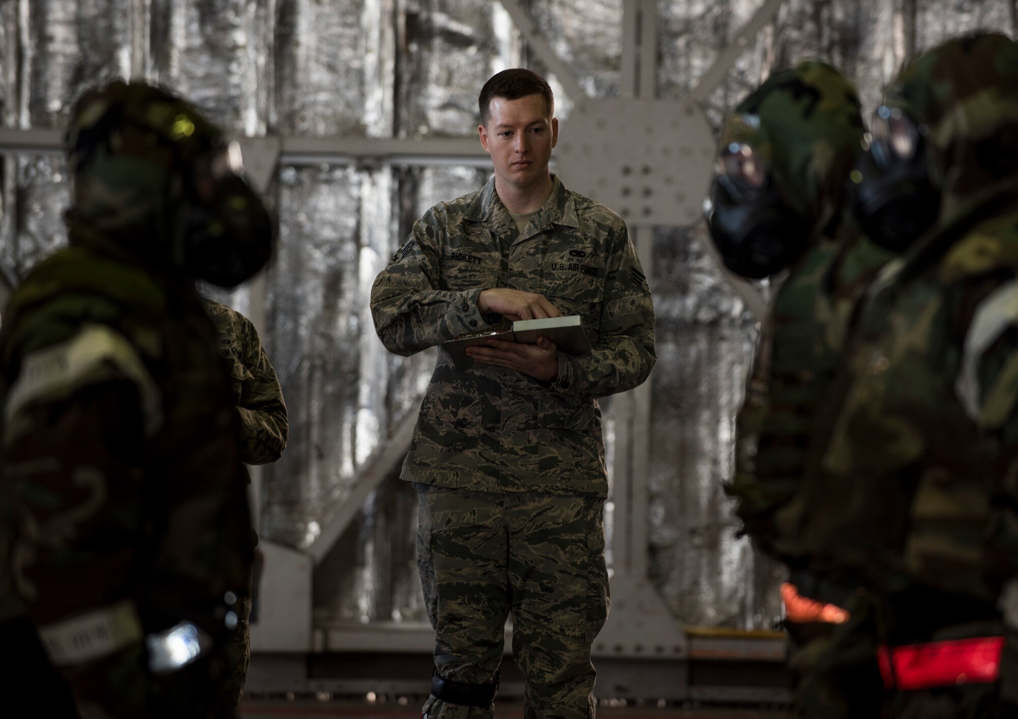 U.S Air Force Senior Airman David Pickett, a weapons standardization lead crew member with the 35th Maintenance Group, watches as Staff Sgt. Nathan Hadama, a weapons team chief with the 35th Aircraft maintenance Squadron, 13th Aircraft Maintenance Unit, dismisses his team during the annual Maintenance Professional of the Year load crew competition at Misawa Air Base, Japan, Jan. 8, 2016. Although the load crew Airmen from the 13 AMU finished first during the competition, the official results will not be announced until the end of March. To determine the winning team, Airmen from weapons standardization will tally all discrepancies each team had from four categories including: loading munitions, a test assessment, dress and appearance and a composite tool inspection. (U.S. Air Force photo by Senior Airman Brittany A. Chase)