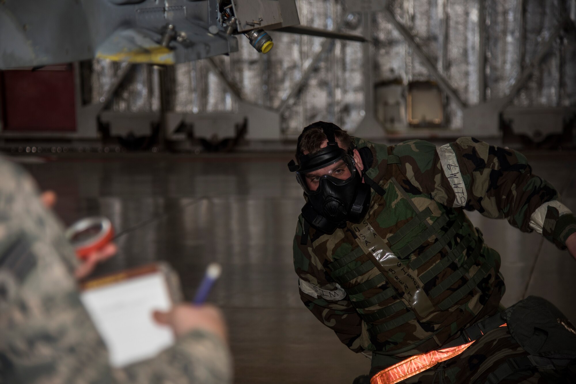 U.S Air Force Senior Airman Kaitlyn McKenzie, a weapons standardization lead crew member with the 35th Maintenance Group, times Senior Airman Brent Gibson, a load crew member from the 35th Aircraft maintenance Squadron, 13th Aircraft Maintenance Unit, as he puts on his mission-oriented protective posture gear during the annual Maintenance Professional of the Year load crew competition at Misawa Air Base, Japan, Jan. 8, 2016. The objective of the weapons load crew competition was to gauge how quickly and efficiently each team was able to arm an F-16 Fighting Falcon. Each of the teams being graded were given a set number of points and then docked for any discrepancies the weapons standardization Airmen observed. (U.S. Air Force photo by Senior Airman Brittany A. Chase)