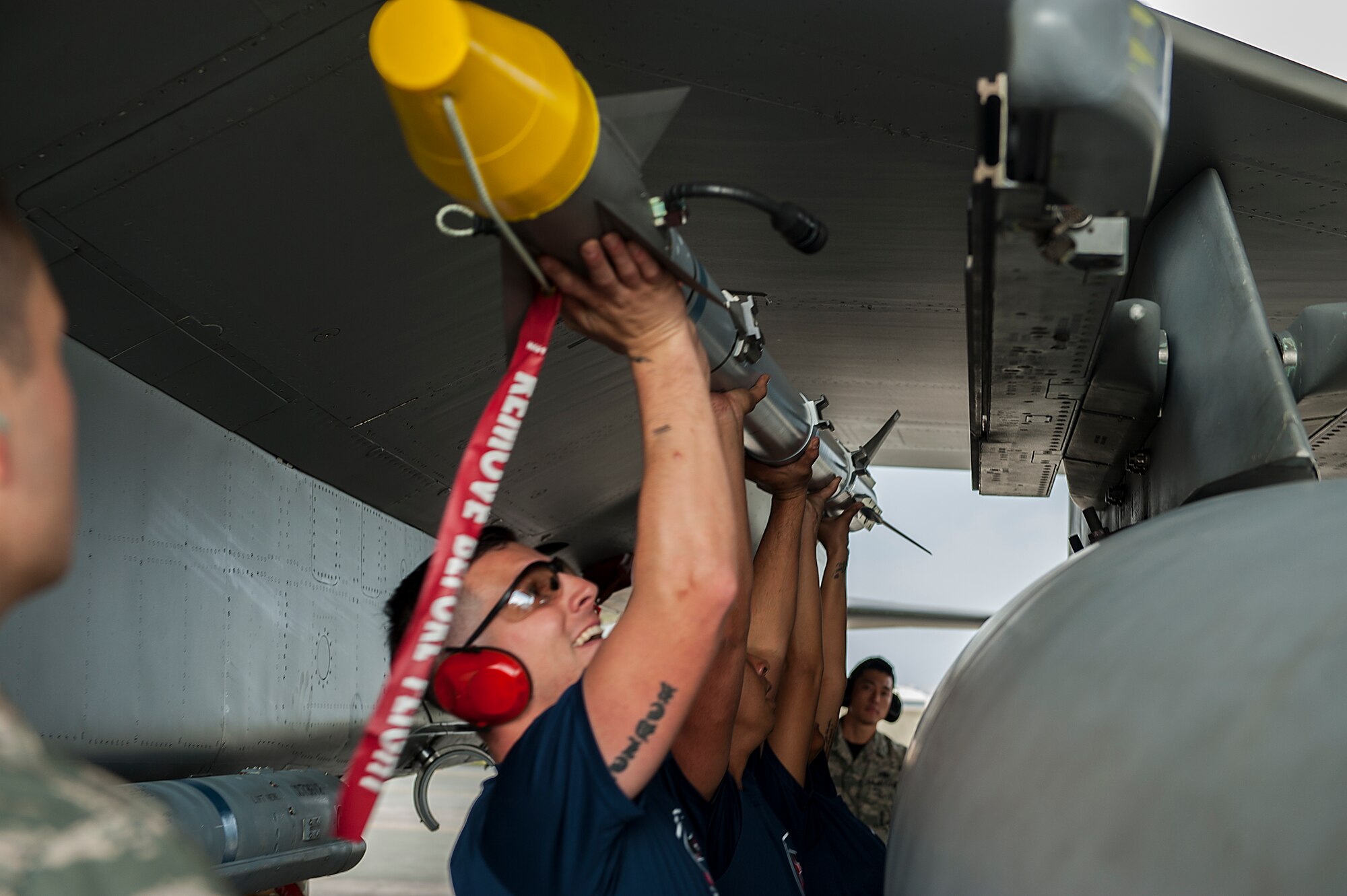 U.S. Air Force, Staff Sgt. Jairek Kahaik and Senior Airmen Dominique Hursey and Ian Swartzwelder, all 18th Aircraft Maintenance Squadron weapons load crew members, load an AIM-9X missile during a weapons load competition Jan. 8, 2016, at Kadena Air Base, Japan. The AIM-9X is an air-to-air, heat-seaking missile used by U.S. Air Force fighter aircraft. (U.S. Air Force photo by Airman 1st Class Corey M. Pettis)