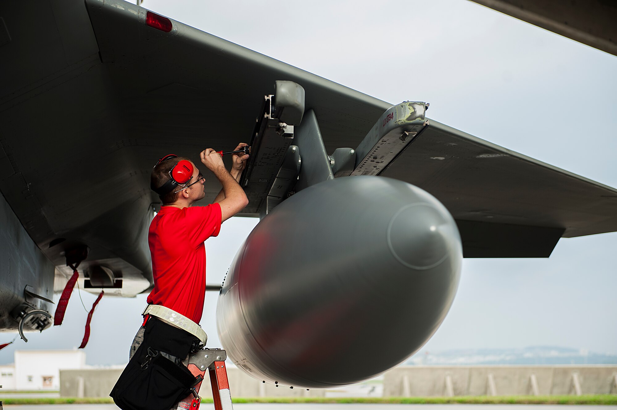 U.S. Air Force Airman 1st Class William Cross, 18th Aircraft Maintenance Squadron weapons load crew member, tightens a bolt in preparation for loading a missile onto the aircraft during a weapons load competition Jan. 8, 2016, at Kadena Air Base, Japan. The weapons load competition is a tradition held to raise morale and give Airmen motivation to outperform their peers.  (U.S. Air Force photo by Airman 1st Class Corey M. Pettis)