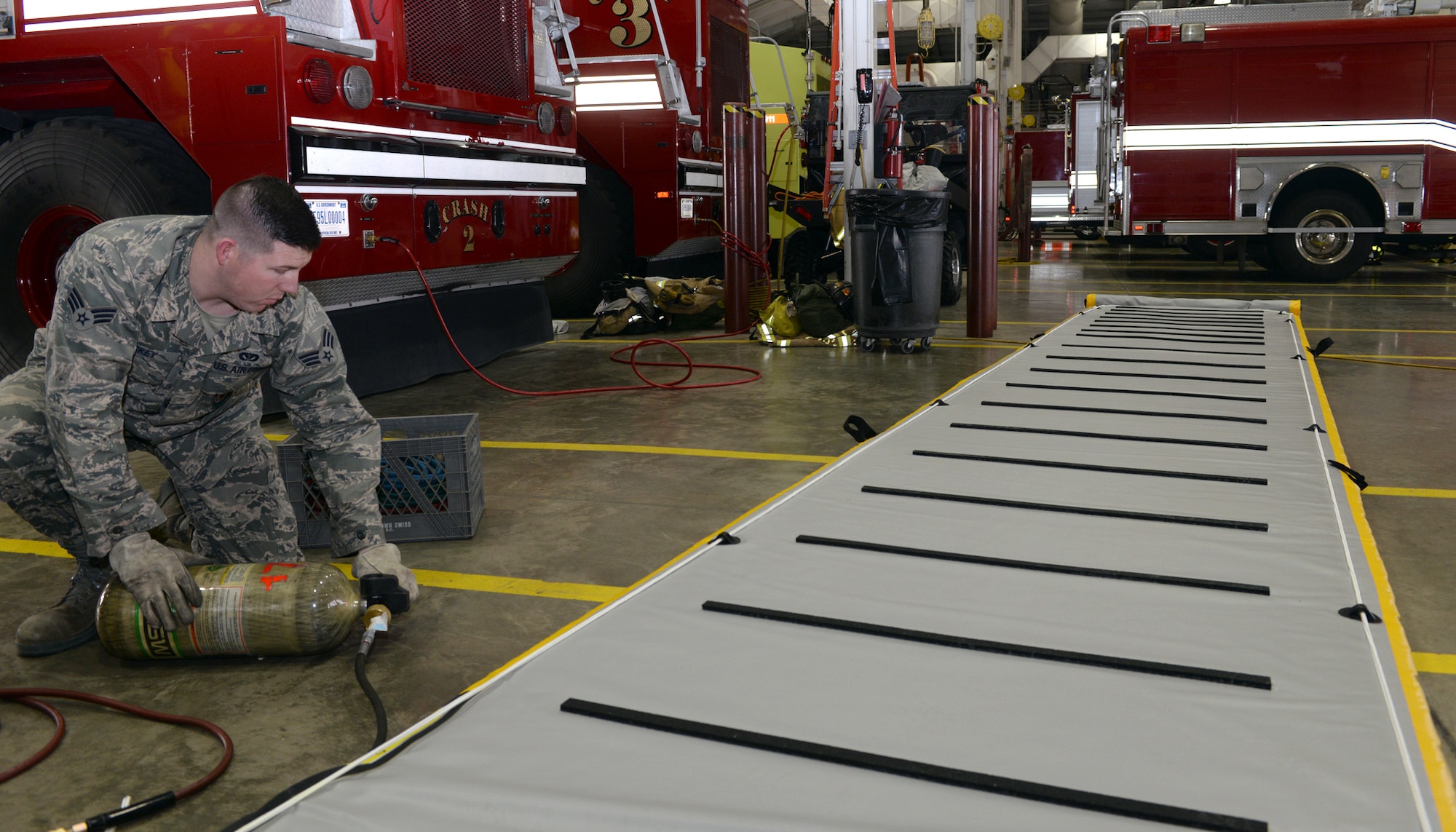 Senior Airman Levi Hickey, 28th Civil Engineer Squadron fire protection flight driver operator, fills a supportable water bridge with pressurized air at Ellsworth Air Force Base, S.D., Jan. 7, 2016. The SWB can be fully inflated and deployable in a 30-second time span and provides a supportive and reliable surface for emergency responders during rescue missions. (U.S. Air Force photo by Airman Donald C. Knechtel/Released) 