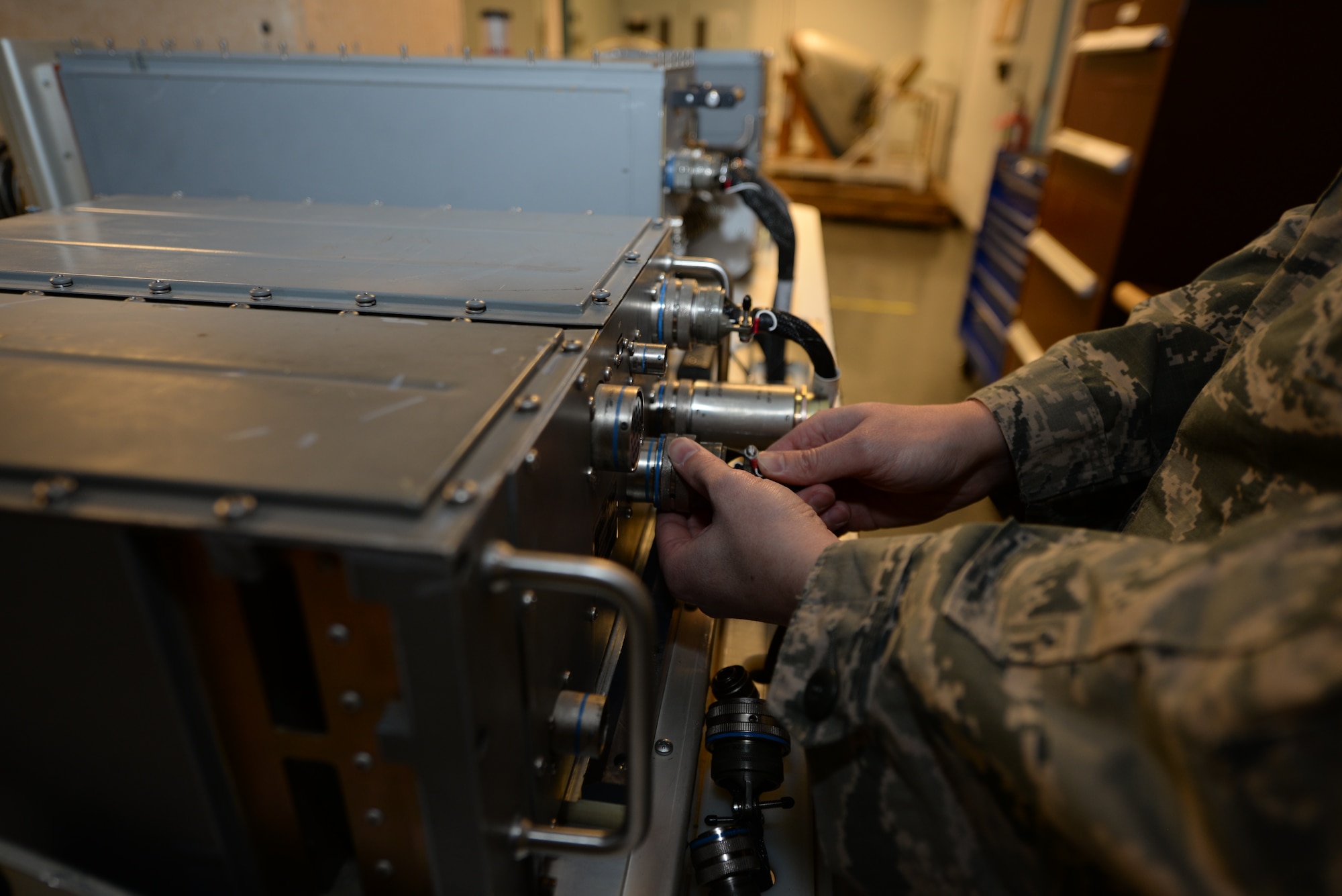 Staff Sgt. Lary Eyre, 28th Maintenance Squadron avionics team leader, connects an electrical plug to a radar video signal processor unit at Ellsworth Air Force Base, S.D., Jan. 6, 2016. The RSVP generates signals that transmit to a radar target indicator, which displays what the aircraft can sense on the ground onto a screen. (U.S. Air Force photo by Airman Sadie Colbert/Released)