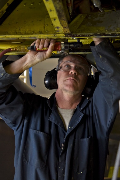 Tech. Sgt. Steven Olander, 141st Maintenance Squadron aircraft structural repair specialist, takes apart a bushing plate during the last phase of the Periodic Inspection Dec. 17, 2015, at Fairchild Air Force Base, Wash. PEs are one of the most in-depth and time consuming inspections completed on an aircraft. (U.S. Air Force photo/ Airman 1st Class Mackenzie Richardson)