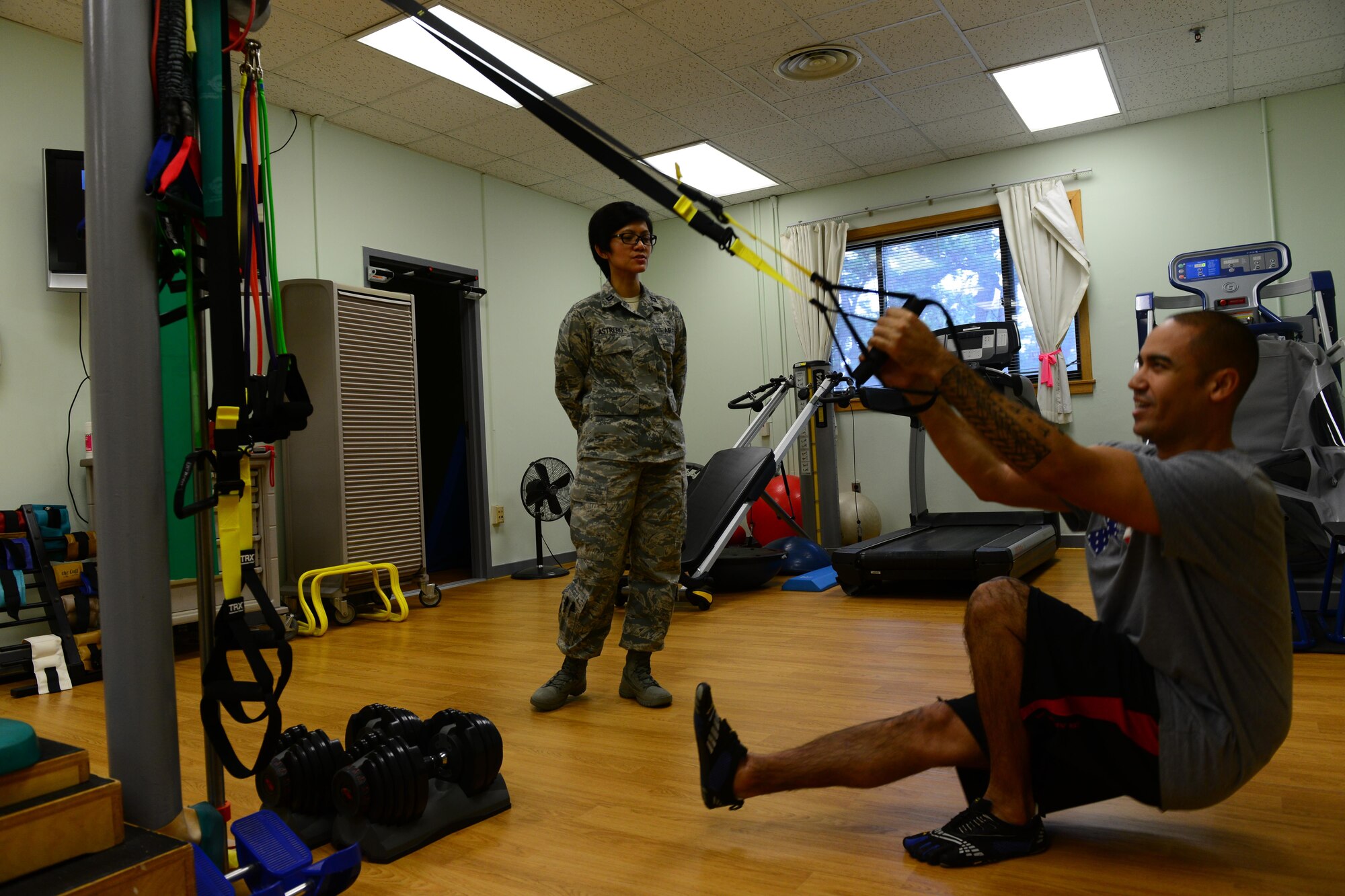 U.S. Air Force Capt.  Jacqueline Astrero, 8th Medical Operations Squadron health promotion flight commander and physical therapist, coaches Tech. Sgt. Anthony Flores, 8th MDOS physical therapy technician during therapy session at Kunsan Air Base, Republic of Korea, Jan. 7, 2016. A physical therapy technician's job is to assist the commander and return active duty members to full duty status, making them fit to fight. (U.S. Air Force photo by Senior Airman Ashley L. Gardner/Released)
