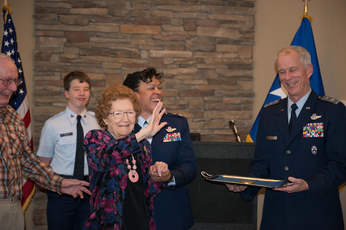 Ms. Cecelia Bell waves during the Congressional Gold Medal ceremony in Faribault, Minn. on Jan. 7. Ms. Bell was presented with the Congressional Gold Medal by Maj. Gen. Stayce Harris, 22nd Air Force commander (center/right), for her service in the Civil Air Patrol during World War II. (U.S. Air Force photo by Capt. William-Joseph Mojica)