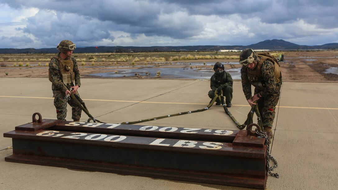 Marines with Combat Logistic Battalion 11 prepare a 6,200 pound steel beam for a CH-53E Super Stallion lift aboard Marine Corps Air Station Miramar, Calif., Jan. 7. Marines with Marine Heavy Helicopter Squadron 465 and CLB-11 practiced daytime external lift training to prepare for deployments. 
