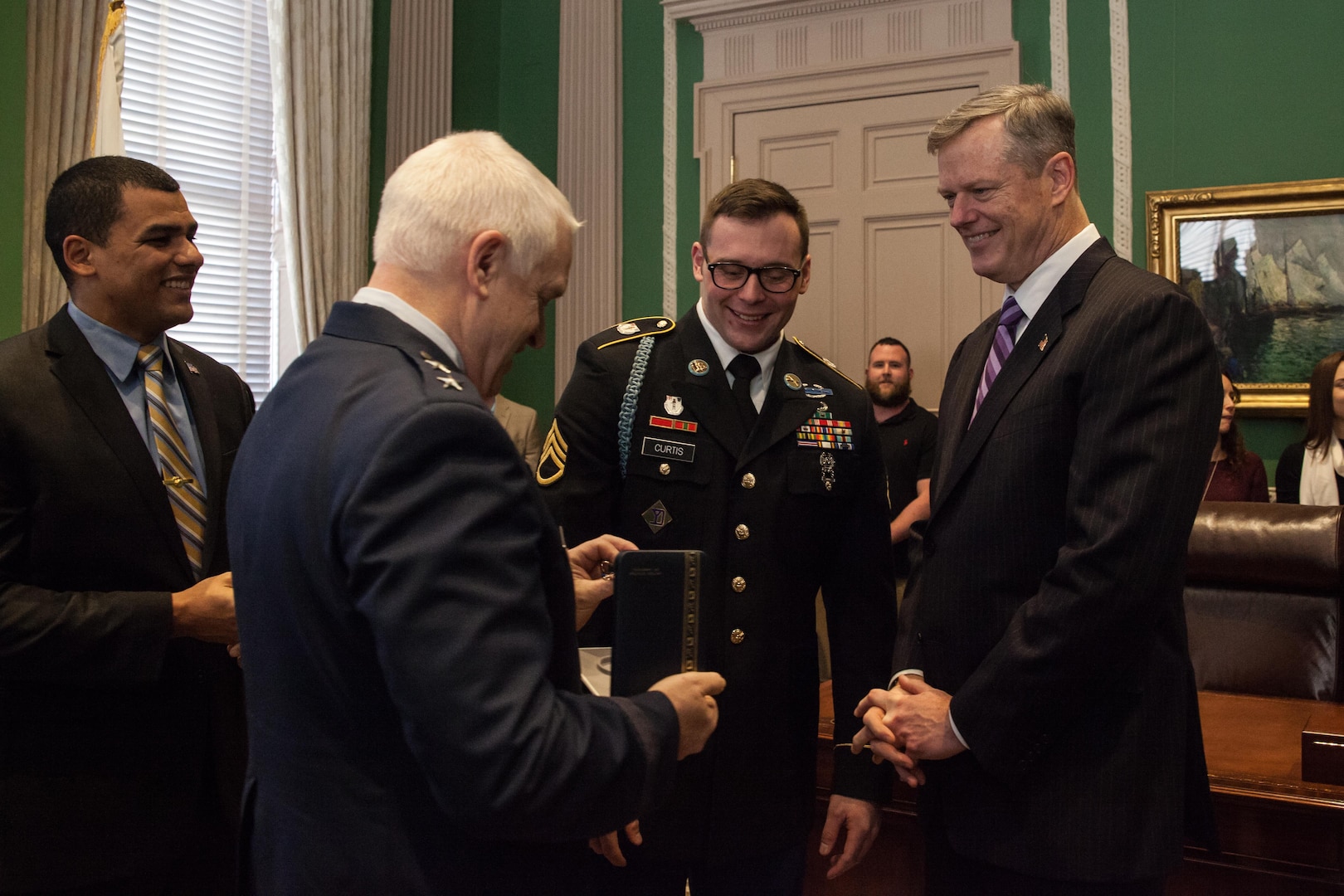 Maj. Gen. L Scott Rice, the adjutant general, presents the Soldiers Medal to Staff Sgt. Geoffrey Curtis. Curtis was awarded the medal by Massachusetts Governor Charlie Baker during a ceremony at the state house January 11, 2016. Curtis' award is in recognition of his swift response and heroic actions immediately following the Boston Marathon bombings in 2013.