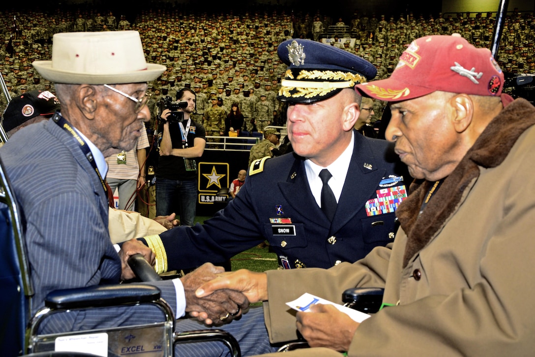 Richard Overton, left, America’s oldest veteran at 109 years old, greets Dr. Granville Coggs, right, a Tuskegee airman, and Army Maj. Gen. Jeffery Snow, center, commander, U.S. Army Recruiting Command, during the pre-game ceremonies of the 2016 U.S. Army All-American Bowl, San Antonio, Texas, Jan. 9, 2016. Overton delivered the game ball for the bowl, while Coggs was introduced to the crowd with fellow Tuskegee airman Theodore Johnson during opening ceremonies. The AAB showcases the top 90 high school football players in the Nation, along with 125 top high school marching band and color guard.U.S. Army photo by Sgt. 1st Class Rauel Tirado