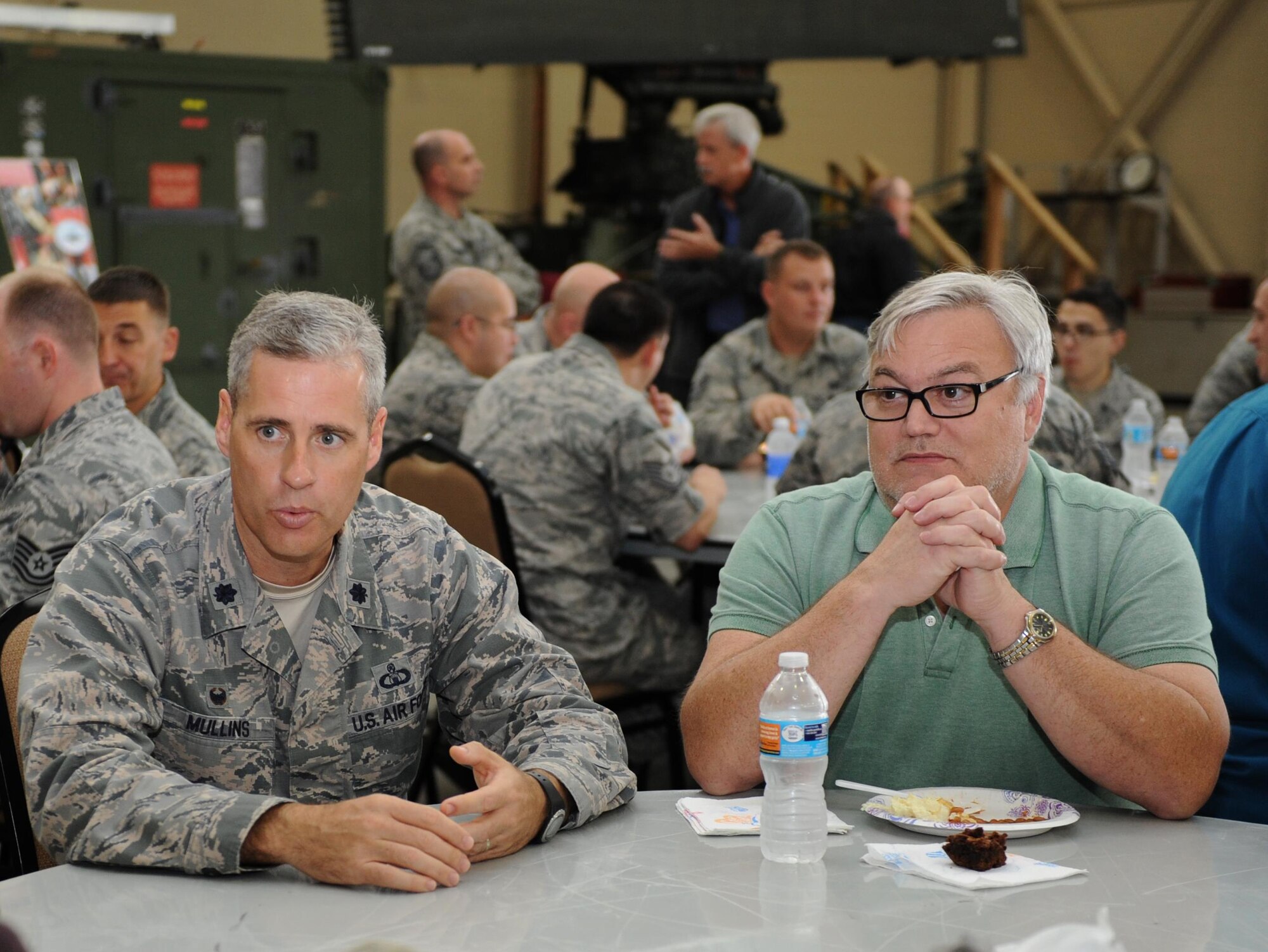 Lt. Col. Steven Mullins, 334th Training Squadron commander, speaks with Jordan Williams, 338th Training Squadron instructor, and other 338th TRS personnel during a luncheon at Matero Hall Dec. 17, 2015, Keesler Air Force Base, Miss. Two Air Force Specialty Codes, 3D1X5 Ground Radar and 3D1X6 Airfield Systems, have been converted to 1C8X1 and 1C8X2, respectively. The 81st Training Group adjusted accordingly and realigned the 41-member flight from the 338th Training Squadron to the 334th Training Squadron effective Jan 4, 2016. The 338th TRS staff held a flight transition luncheon to thank them for their contributions and dedicated service to the unit. (U.S. Air Force photo by Kemberly Groue)