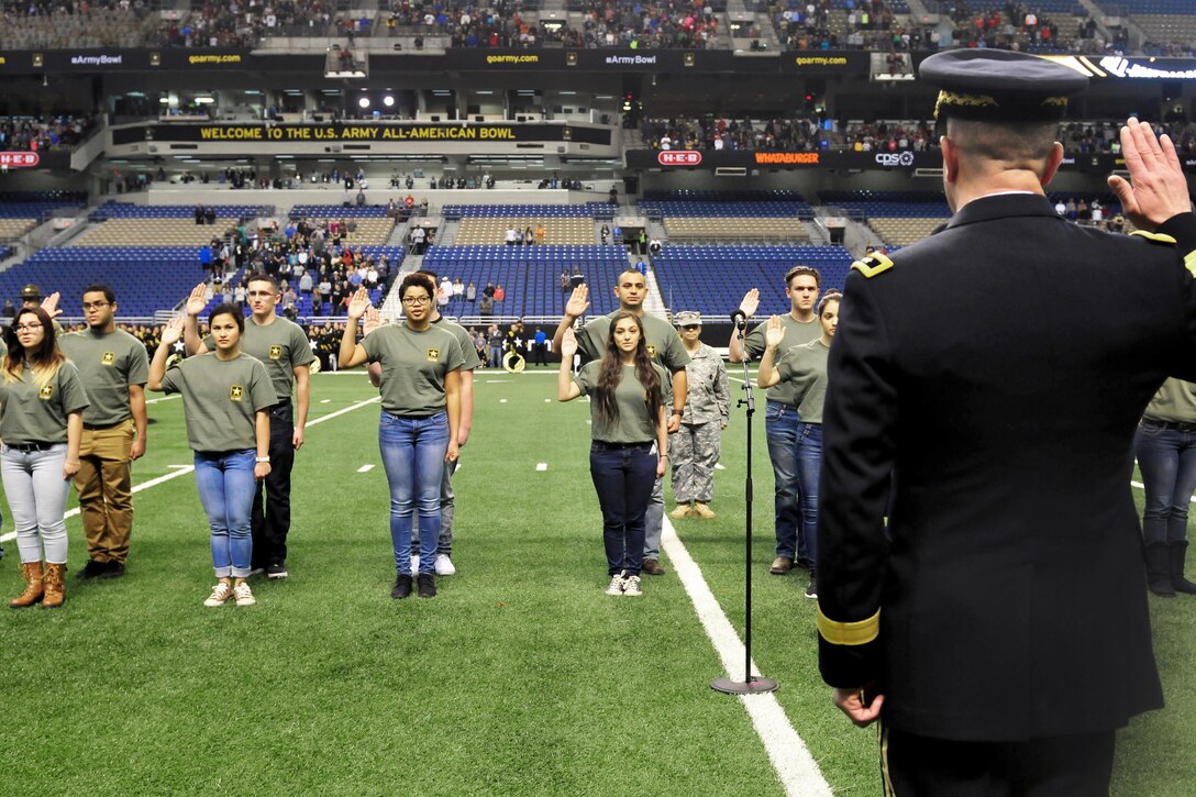 Army Maj. Gen. Jeffery Snow, right, commander, U.S. Army Recruiting Command, administers the oath of enlistment to new soldiers at the Alamodome before the 2016 All-American Bowl in San Antonio, Texas, Jan. 9, 2016. U.S. Army Photo by Sgt. Bethany L. Huff