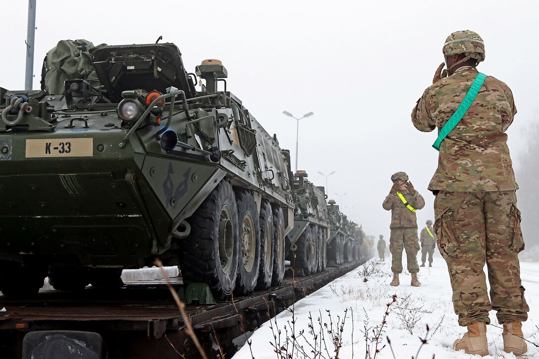 U.S. Army Sgt. Ryan Powell, right, and Spc. Tyler Minnick, rear, use hand signals to guide a Stryker armored vehicle during railhead operations in Konotop, Poland, Jan. 11, 2016. Unloading vehicles and equipment is part of the training mission to support Atlantic Resolve, a multinational demonstration of continued U.S. commitment to the collective security of NATO allies. Powel and Minnick are infantrymen assigned to 3rd Squadron, 2nd Cavalry Regiment. U.S. Army photo by Sgt. Paige Behringer