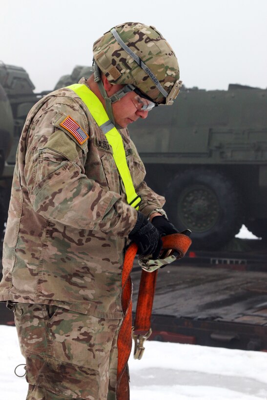 U.S. Army Spc. Raymon Najera untangles a ratchet strap used to tie down a vehicle for transportation by train during railhead operations in Konotop, Poland, Jan. 11, 2016. Najera and his troop arrived in Poland recently to conduct a five month training rotation in support of Operation Atlantic Resolve, a multinational demonstration of continued U.S. commitment to the collective security of NATO allies. U.S. Army photo by Sgt. Paige Behringer