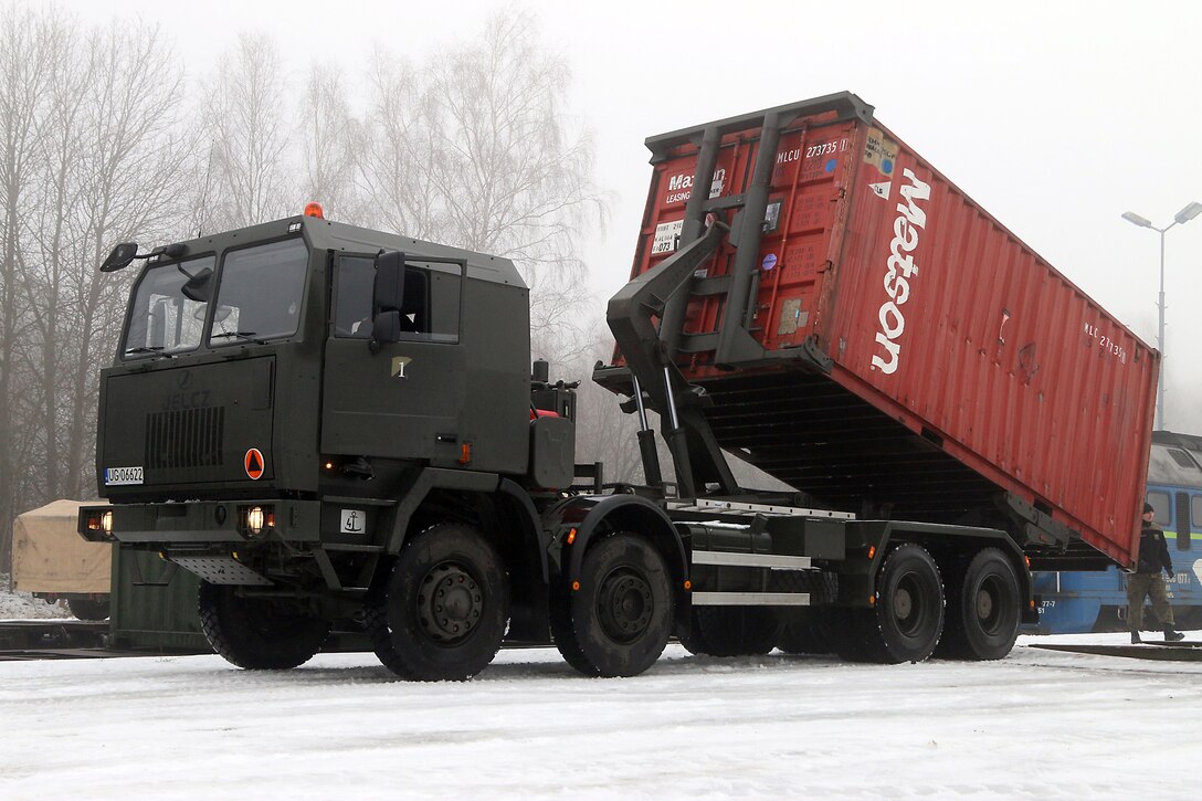 Polish soldiers help U.S. soldiers remove and transport shipping containers from the train during railhead operations in Konotop, Poland, Jan. 11, 2016. U.S. Army photo by Sgt. Paige Behringer