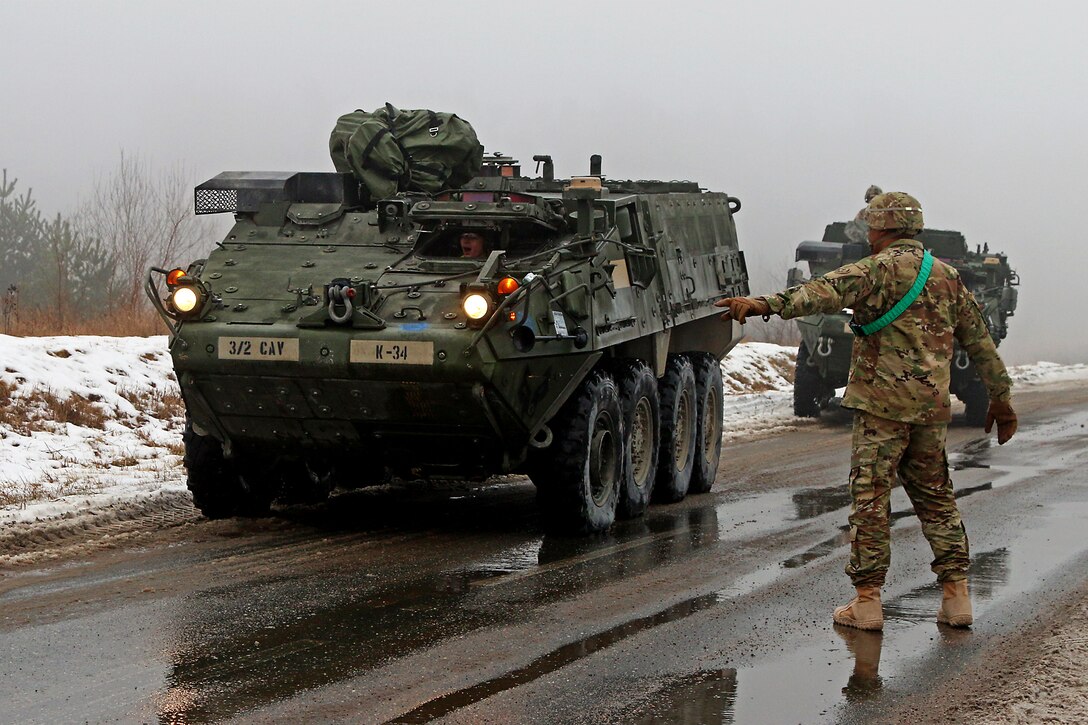 U.S. Army 1st Sgt. William Terry guides a convoy of Stryker armored fighting vehicles during railhead operations in Konotop, Poland, Jan. 11, 2016. Terry’s unit, Knight Troop, 3rd Squadron, 2nd Cavalry Regiment, will train alongside Polish soldiers for five months in support of Operation Atlantic Resolve. U.S. Army photo by Sgt. Paige Behringer