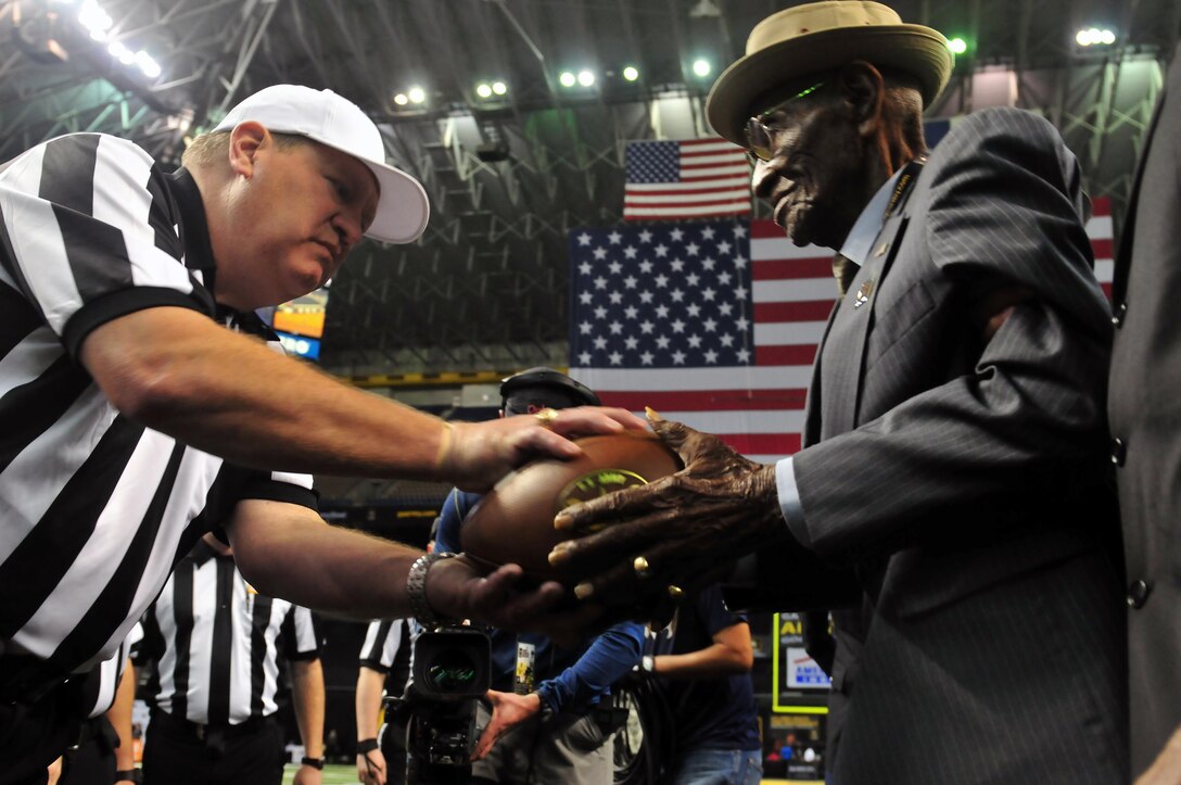 Richard Overton, right, one of the oldest-living World War II veterans, passed the game ball to the referees before the 2016 All-American Bowl in San Antonio, Jan. 9, 2016. Overton served with the 1887th Aviation Engineer Battalion. U.S. Army Photo by Sgt. Bethany L. Huff