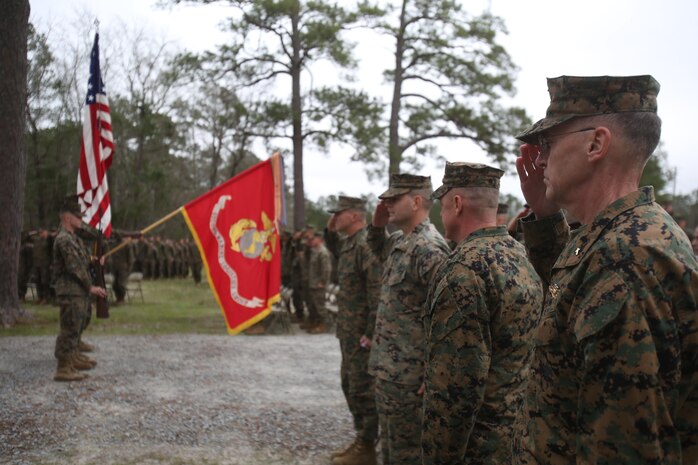 U.S. Navy Capt. Bill Muhm, 2nd Marine Logistics Group chaplain, salutes as the colors are presented before the new 2nd MLG Corporals Course building during a ribbon cutting ceremony at Camp Lejeune, N.C., Jan. 6, 2016. Officers and enlisted Marines from various MLG units gathered to unveil the new training center, which is now open for use. (U.S. Marine Corps photo by Lance Cpl. Miranda Faughn/Released)