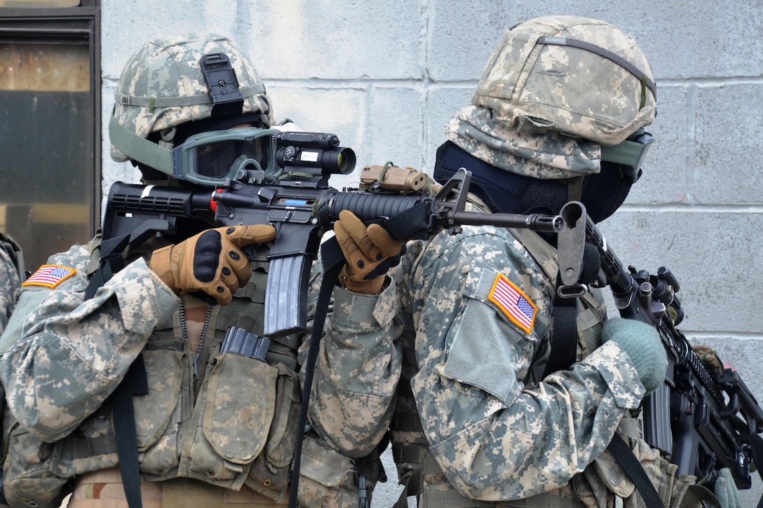A New York Army National Guardsman uses a team member's shoulder to steady his aim while other soldiers maneuver outside a building during tactical training at the New York Police Department training facility and range at Rodman’s Neck, New York, Jan. 9, 2016. New York Army National Guard photo