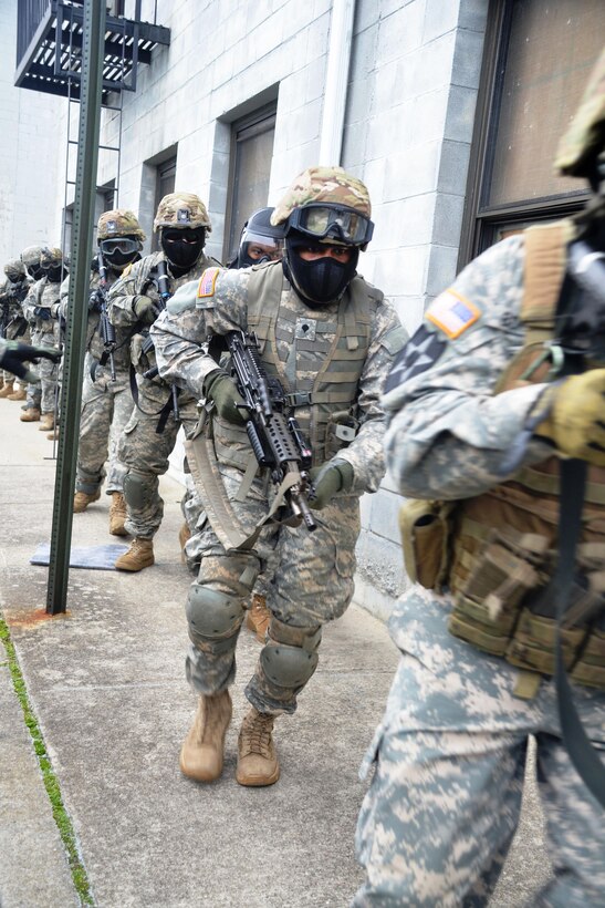 New York Army National Guardsmen maneuver along a building during tactical training at the New York Police Department training facility and range at Rodman’s Neck, New York, Jan. 9, 2016. New York Army National Guard photo