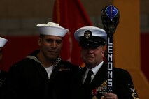 Master Chief Petty Officer Robert Lemons (right), the command master chief of the 1st Marine Division, holds up a decorated paddle he received from the Sailors under his charge during his retirement ceremony aboard Marine Corps Base Camp Pendleton, Calif., Jan. 8, 2016. Lemons enlisted in the U.S. Navy in 1986 and served a majority of his time in the service as a corpsman.