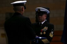 Master Chief Petty Officer Robert Lemons (right), the command master chief of the 1st Marine Division, receives a folded flag during the Old Glory presentation as part of his retirement ceremony aboard Marine Corps Base Camp Pendleton, Calif., Jan. 8, 2016. Lemons enlisted in the U.S. Navy in 1986 and served a majority of his time in the service as a corpsman.