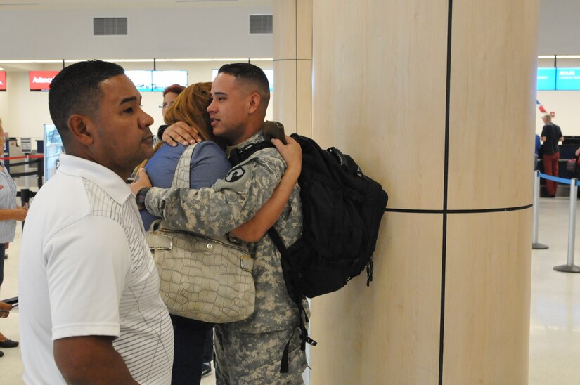 Private 1st Class Luis Marcano, Human Resources Specialist, 271st HR CO, hugs his mother, Madeline Rivera before departing to his mobilization training in Texas on January 12, 2016. 