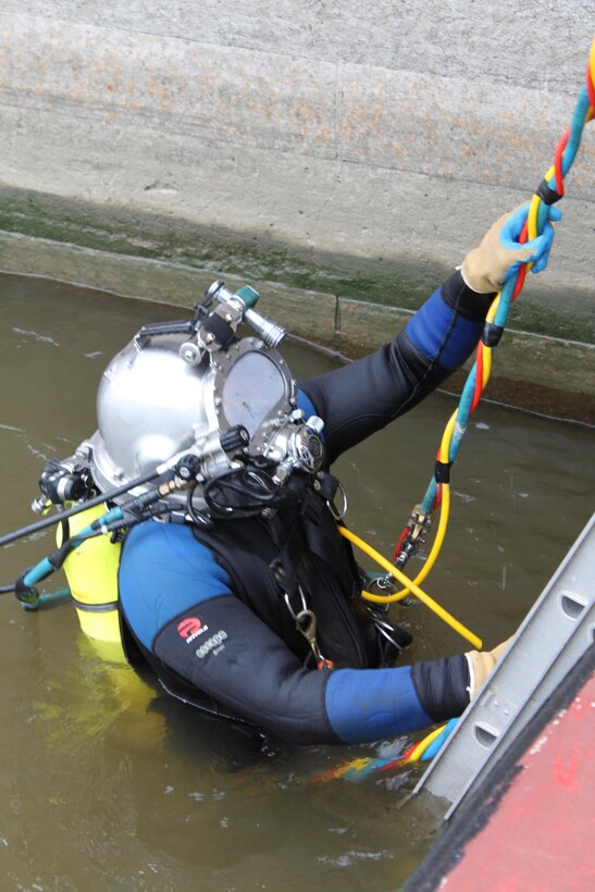 Dive team member John Snell enters the water at Locks and Dam 15 for an inspection of the shifting lower guidewall.
