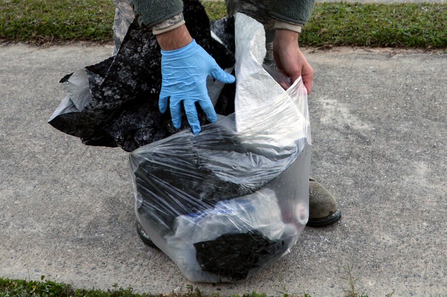 U.S. Air Force Staff Sgt. Matthew Harris, 23d Operation Support Squadron air traffic control craftsman, bags garbage during a Pride Patrol clean-up, Jan. 12, 2016, at Moody Air Force Base, Ga. Volunteers were required to wear gloves as a safety precaution while picking up trash along the base perimeter. (U.S. Air Force photo by Airman 1st Class Janiqua P. Robinson/Released)