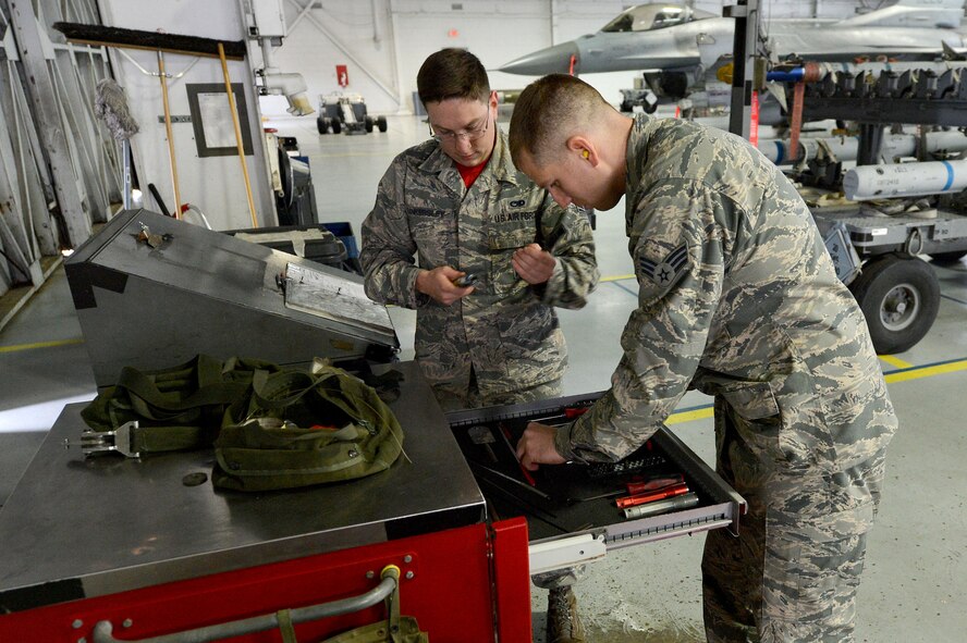 U.S. Air Force Senior Airman Justin Tankersley and Senior Airman Jackson Crammer, both 20th Aircraft Maintenance Squadron, 77th Aircraft Maintenance Unit weapons load crew members, organize their tools during a load crew of the quarter competition at Shaw Air Force Base, S.C., Jan. 8, 2016. The quarterly competition demonstrates the weapons load crew members’ and chiefs’ ability to load munitions onto an F-16CM Fighting Falcon efficiently. (U.S. Air Force photo by Senior Airman Diana M. Cossaboom)