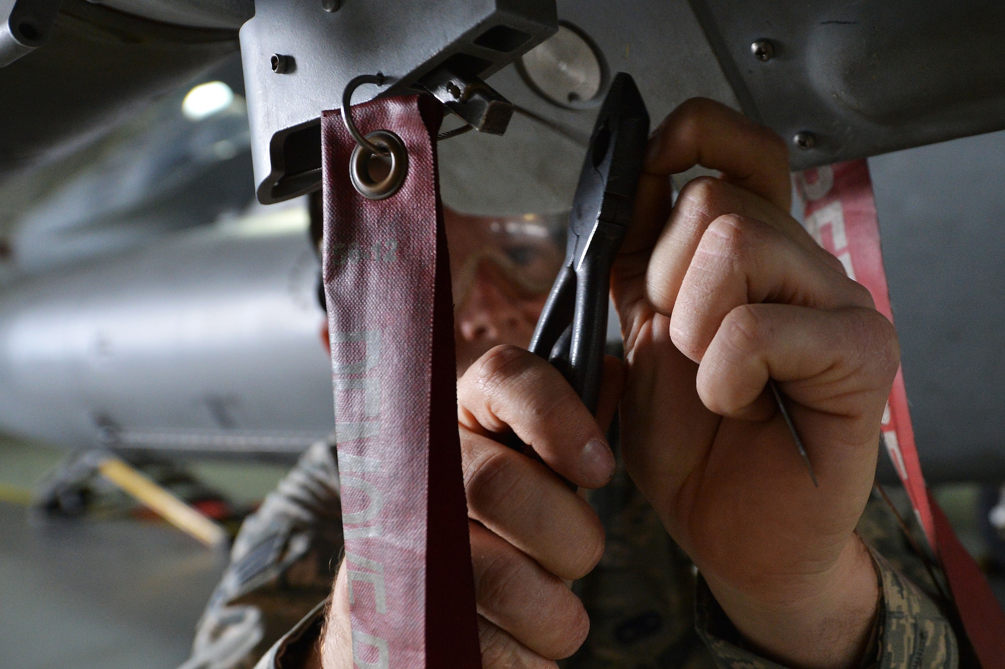 U.S. Air Force Senior Airman Jackson Crammer, 20th Aircraft Maintenance Squadron, 77th Aircraft Maintenance Unit weapons load crew member, prepares an F-16CM Fighting Falcon for a GBU-12 munition during a weapons load crew of the quarter competition at Shaw Air Force Base, S.C., Jan. 8, 2016. The competition displays the capability of the weapons load crew members and chiefs to quickly and efficiently load munitions onto an F-16. (U.S. Air Force photo by Senior Airman Diana M. Cossaboom)