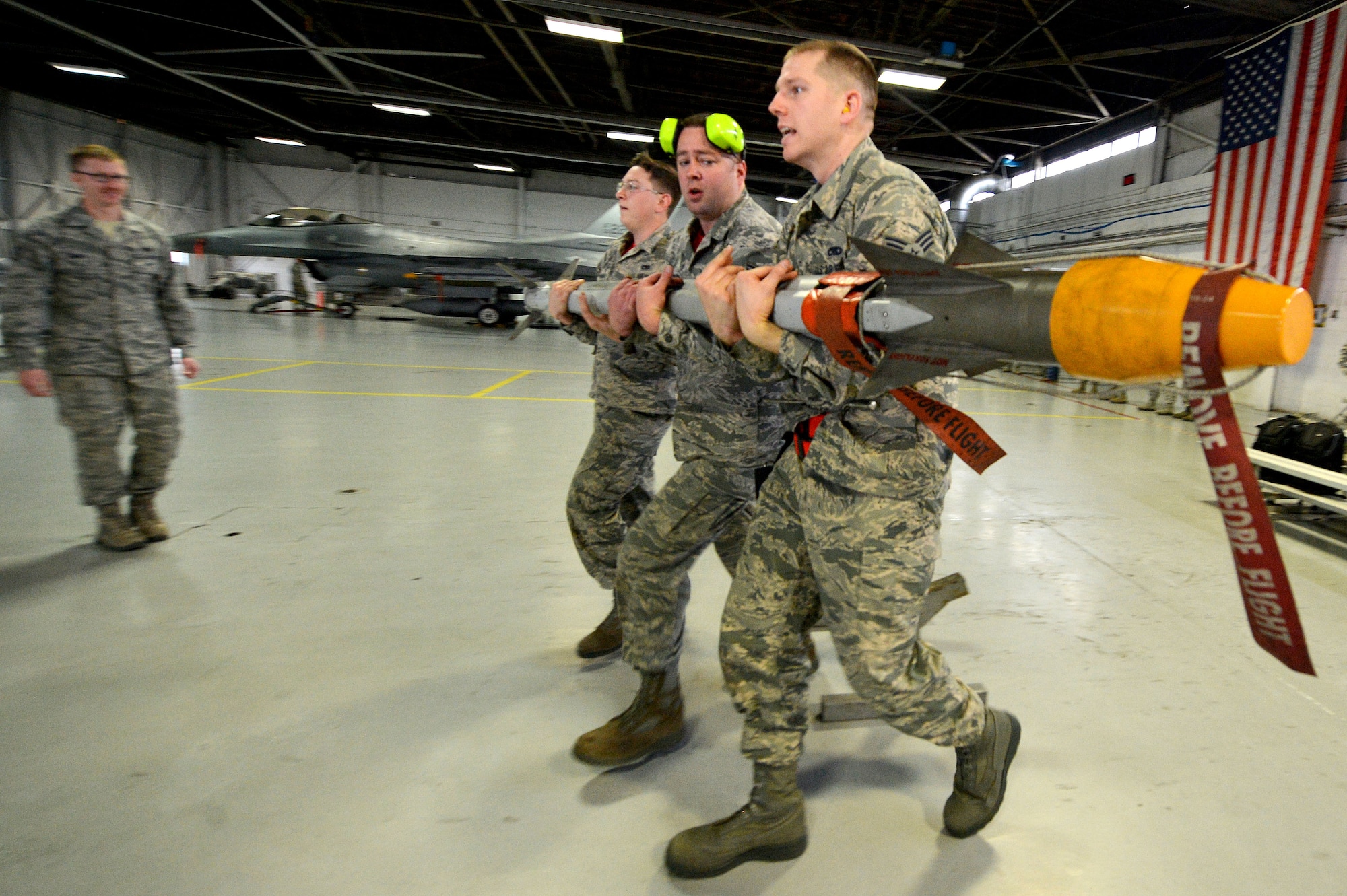 U.S. Airmen assigned to the 20th Aircraft Maintenance Squadron, 77th Aircraft Maintenance Unit, carry an AIM-9X munition during a weapons load crew of the quarter competition at Shaw Air Force Base, S.C., Jan. 8, 2016. Teams competed against each other on the accuracy and time it took to load the GBU-38, GBU-12, and AIM-9X munitions onto an F-16CM Fighting Falcon. (U.S. Air Force photo by Senior Airman Diana M. Cossaboom)
