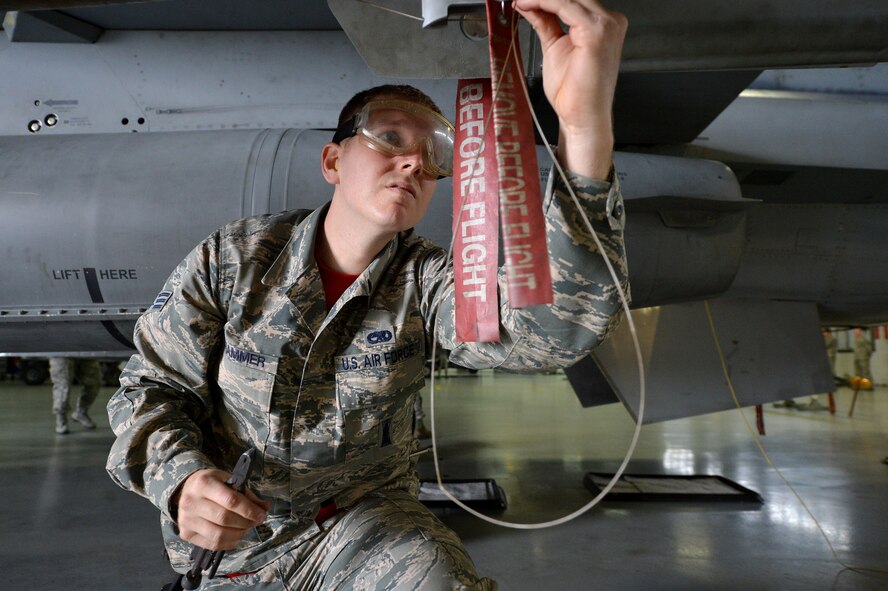 U.S. Air Force Senior Airman Jackson Crammer, 20th Aircraft Maintenance Squadron, 77th Aircraft Maintenance Unit weapons load crew member, works with his team, crew 77-15, to prepare the F-16CM Fighting Falcon to carry munitions during a weapons load crew of the quarter competition at Shaw Air Force Base, S.C., Jan. 8, 2016. Each team consists of two weapons load crew members and a weapons load crew chief. (U.S. Air Force photo by Senior Airman Diana M. Cossaboom)