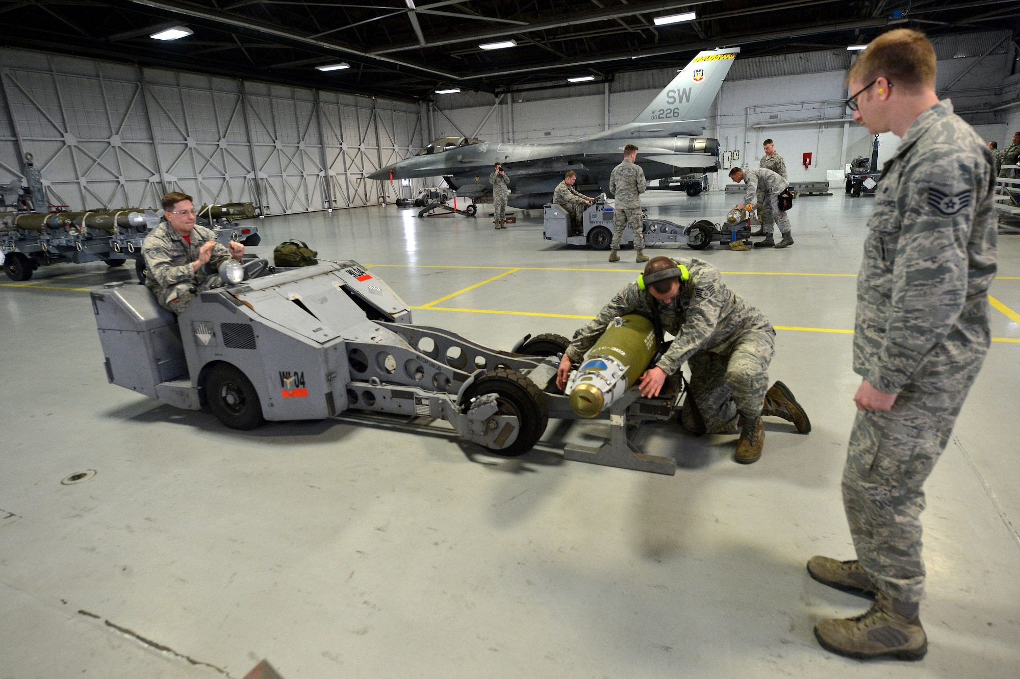 U.S. Airmen assigned to the 20th Aircraft Maintenance Squadron work neck-and-neck to load a GBU-38 munition during a weapons load crew of the quarter competition at Shaw Air Force Base, S.C., Jan. 8, 2016. The competition measures the crew’s speed, accuracy, and safety while loading munitions onto an F-16CM Fighting Falcon. (U.S. Air Force photo by Senior Airman Diana M. Cossaboom)