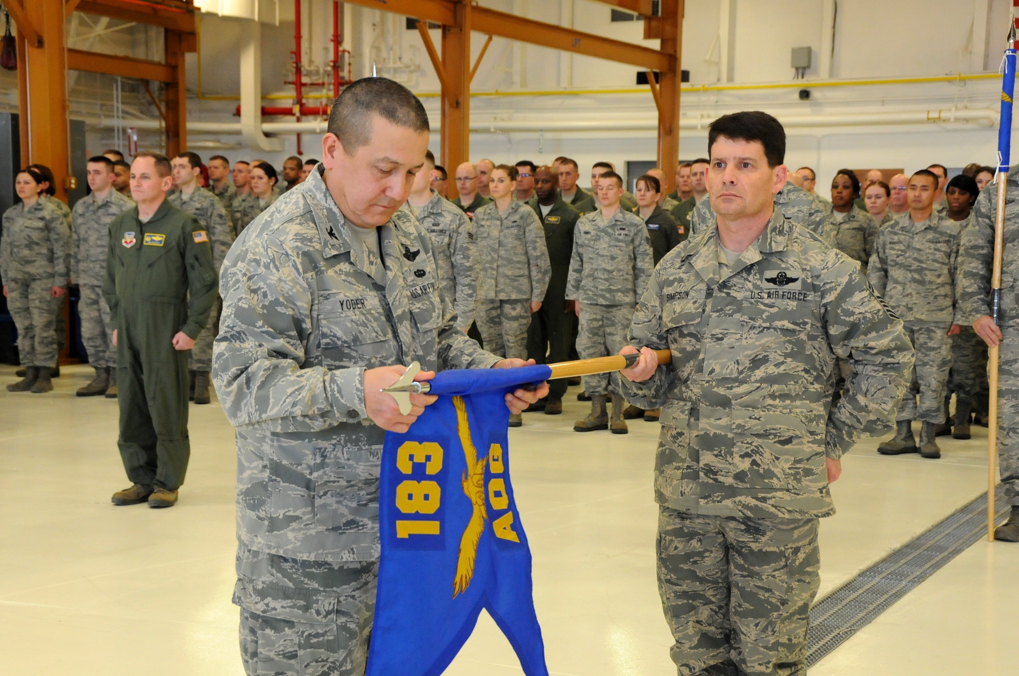 Col. Rick G. Yoder, commander of the 183rd Air Operations Group in Springfield, Illinois, unfurls a flag to mark the activation of units given new roles in a ceremony here Jan. 10, 2016.  The Illinois Air National Guard unit is responsible for command and control missions in combat theaters around the world.  Yoder is assisted by the group’s First Sergeant, Senior Master Sgt. Brent Simpson (U.S.  Air National Guard photo by Master Sgt. Shaun Kerr/Released)