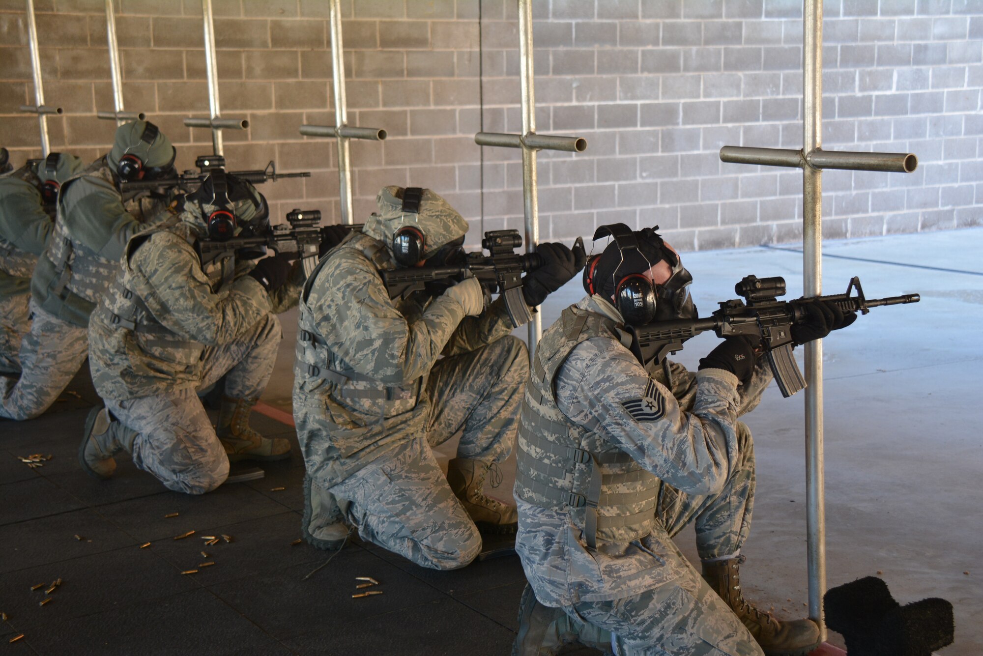 Members of the 507th Air Refueling Wing wear gas masks and cold weather gear while firing the M-4 carbine in below-freezing temperatures Jan. 10, 2016, at the firing range at Tinker Air Force Base, Okla. The Reservists must shoot at targets from a multitude of positions in order to demonstrate agility in their defense capabilities. (U.S. Air Force photo/Tech. Sgt. Charles Taylor)
