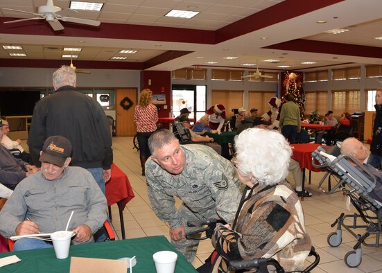 Tech. Sgt. Herbert Briscoe of the 507th Maintenance Squadron, Tinker Air Force Base, Okla., speaks with a resident’s sister Dec. 22, 2015, at the Norman Veterans Center in Norman, Okla. This year marked the19th year that the 507th Air Refueling Wing has participated in the annual Christmas party at the center. (U.S. Air Force photo by Maj. Jon Quinlan)