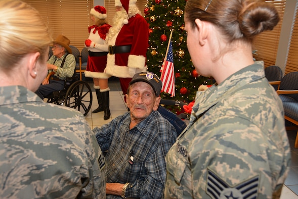 Veteran Robert Black, a Purple Heart recipient, tells Staff Sgts. Ashley White and Sarah Haggard of the 507th Air Refueling Wing a war story Dec. 22, 2015, at the Norman Veterans Center in Norman, Okla. Twenty-five members of the 507th ARW and their families attended the annual Angel Tree party, delivering gifts to 20 Veterans and nearly $700 toward the resident’s benefit fund. (U.S. Air Force photo/Maj. Jon Quinlan)